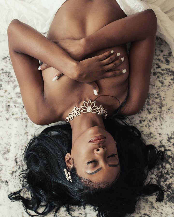 Overhead portrait of a woman with crossed arms wearing a pearl floral choker